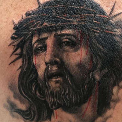 tatuaje de cristo en la pierna
